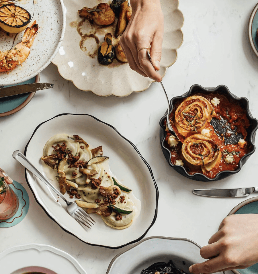 A photograph of an Italian meal on a white table cloth shot from above