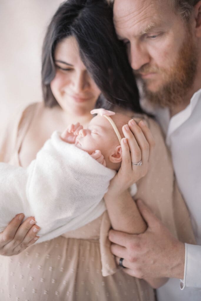 Jacksonville newborn photographer capturing emotional family photos with new baby in studio