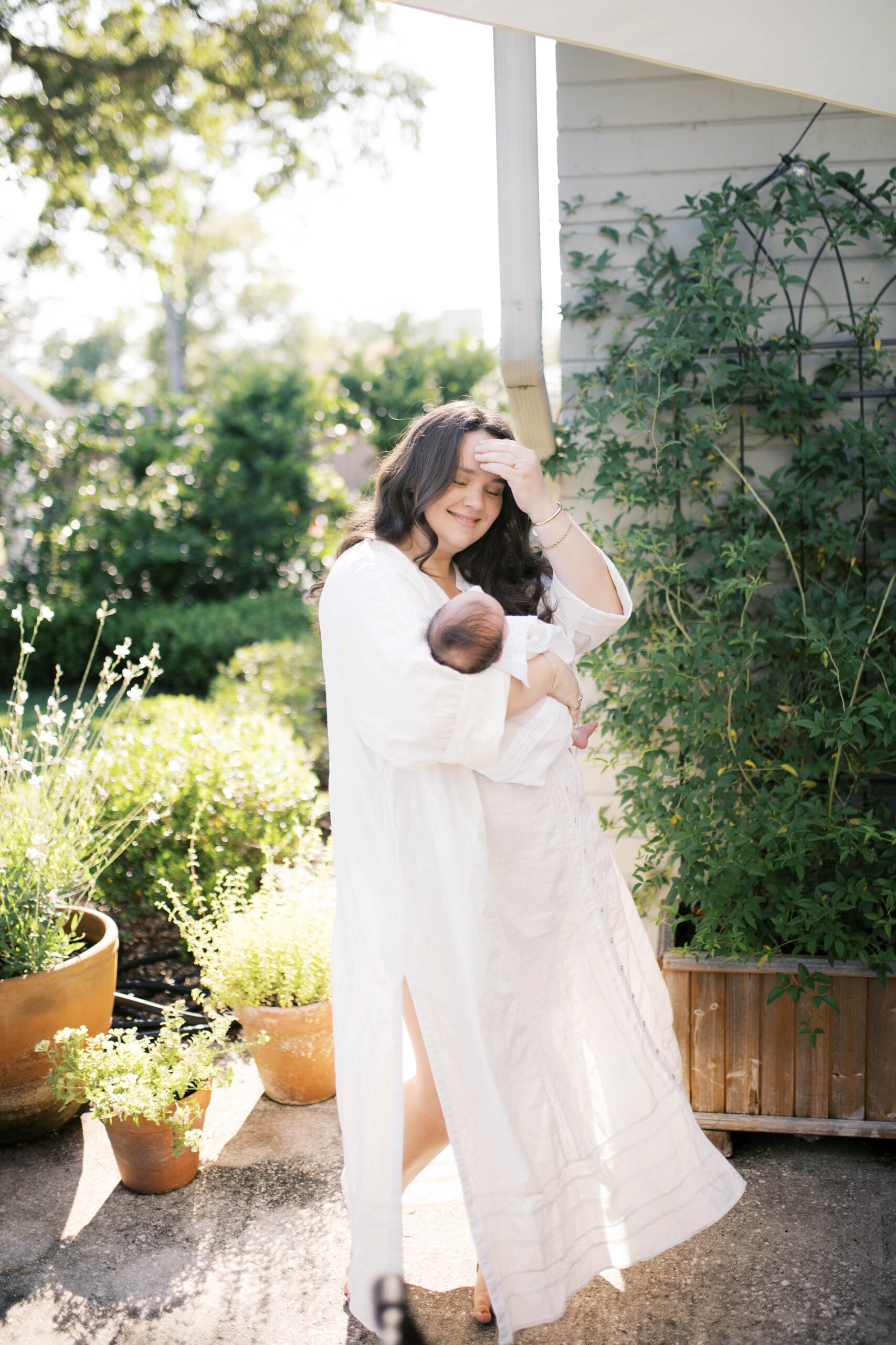 newborn portrait in a backyard at a home in ortega of mom swaying baby girl in the sun