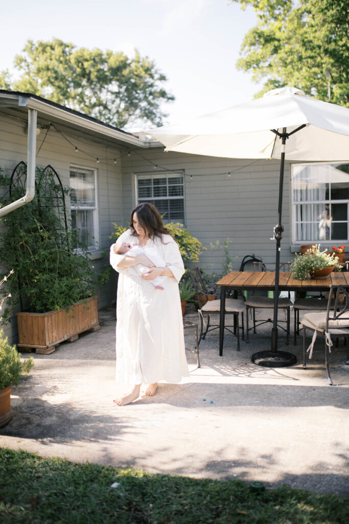 Mom holding baby girl in well designed Ortega backyard