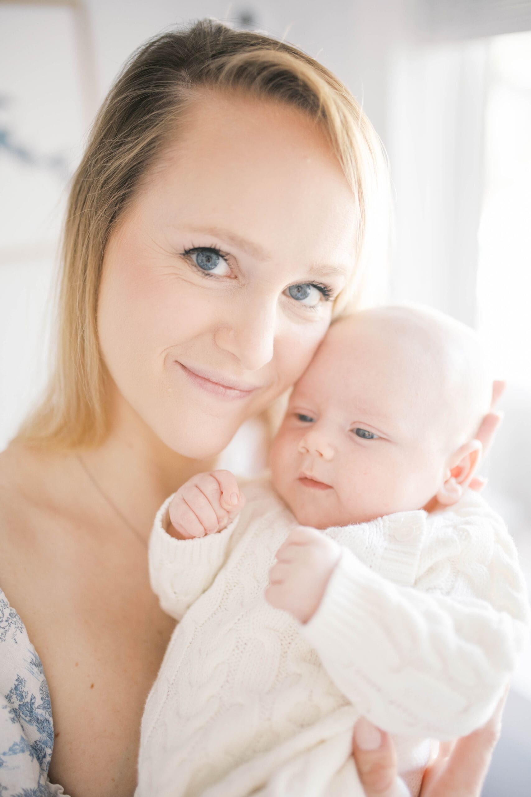 In Home Lifestyle newborn portrait taken in a home in jacksonville beach with mom holding her 12 week old son up to her cheek and smiling