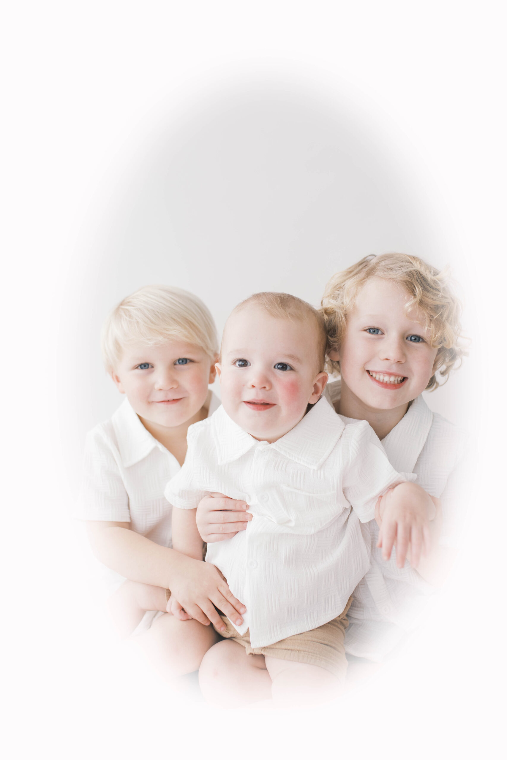 Heirloom portrait of three brothers together smiling at the camera with a white background in a studio in Jacksonville, FL
